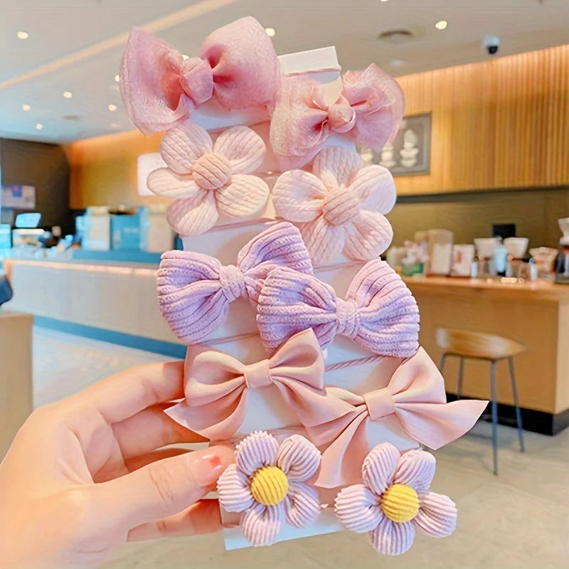 KawaiiLands pastel pink and purple floral bow hair clips set, held in comfy cute cafe setting